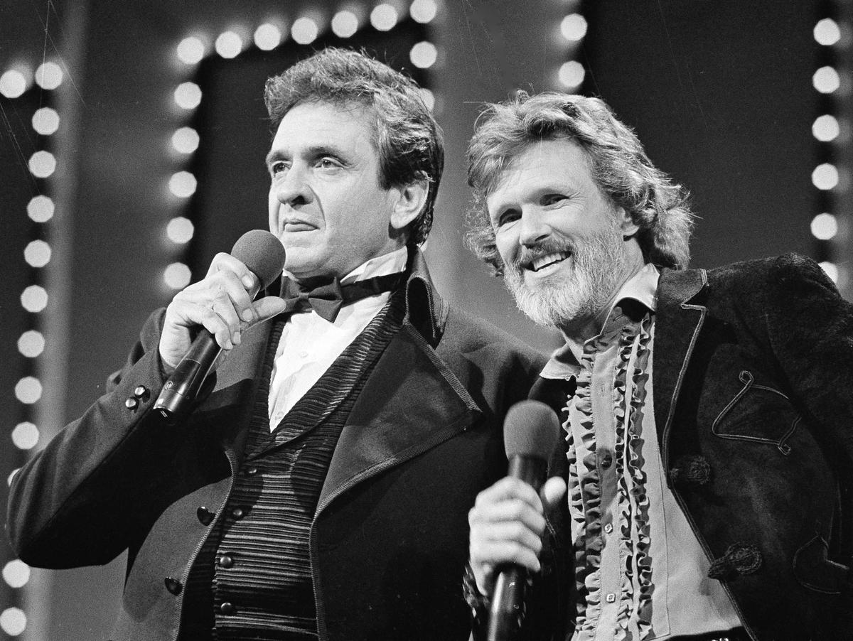 FILE - Country stars Johnny Cash, left and Kris Kristofferson sing during the Country Music Awards in Nashville, Tenn., Oct. 1983.