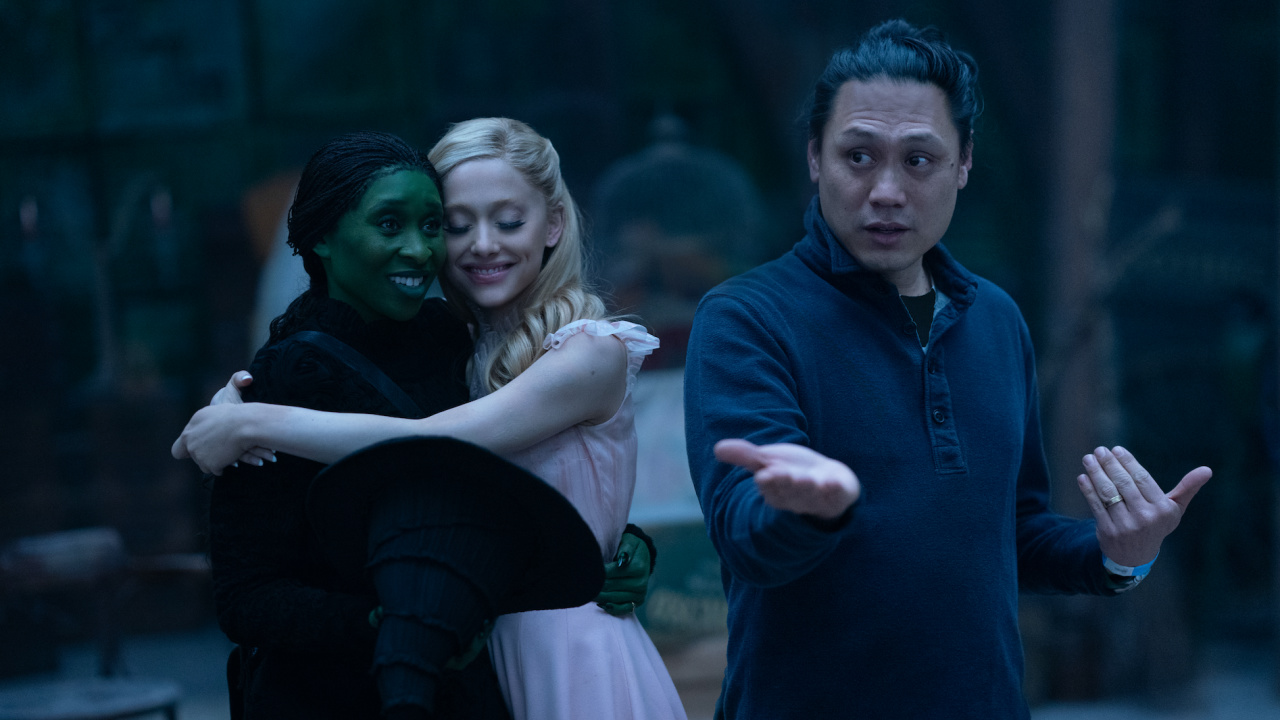 (L to R) Cynthia Erivo is Elphaba, Ariana Grande is Glinda and Director Jon M. Chu on the set of 'Wicked', directed by Jon M. Chu. Photo: Universal Pictures.